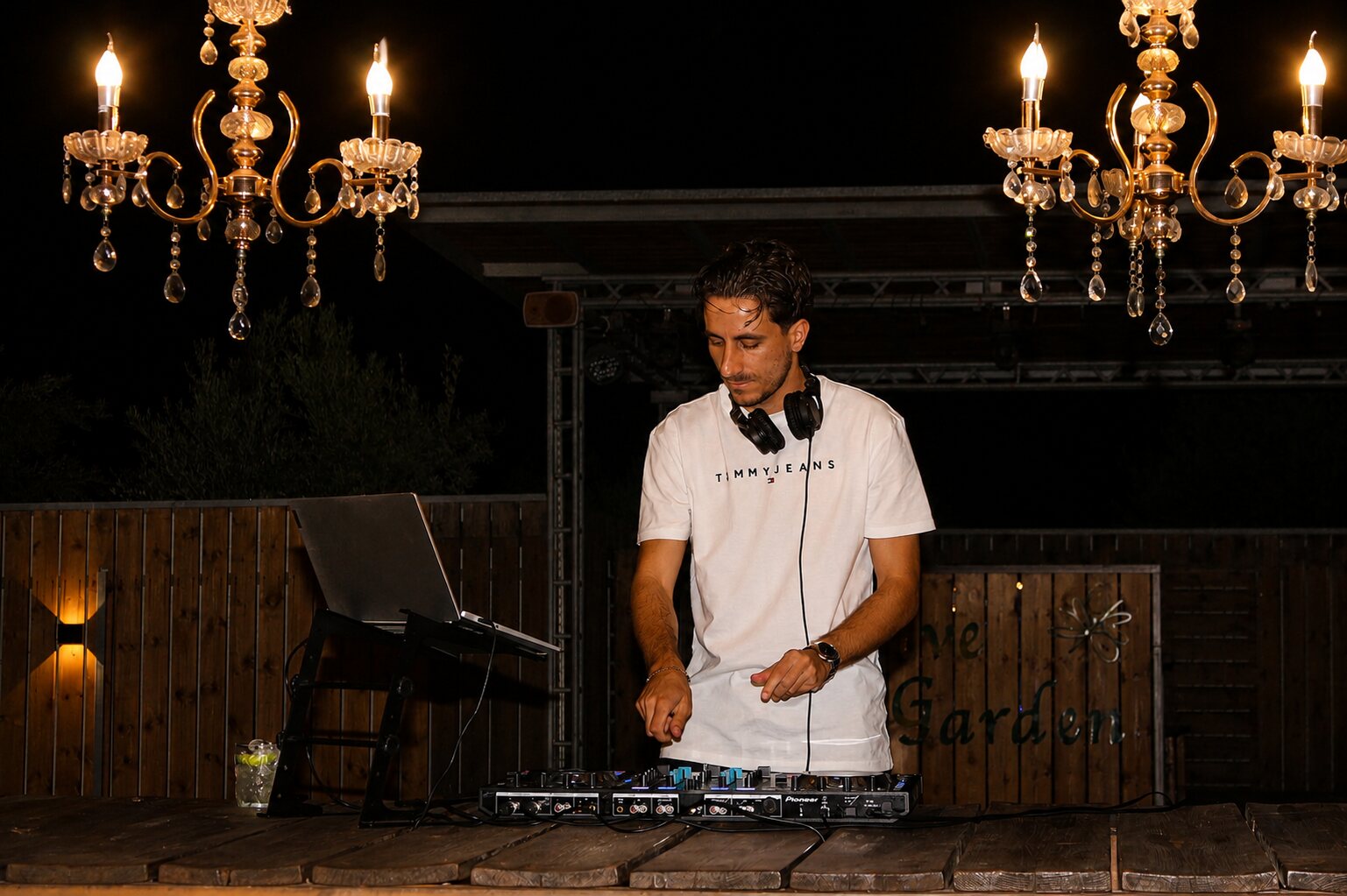 DJ Vrontis behind the decks under chandeliers